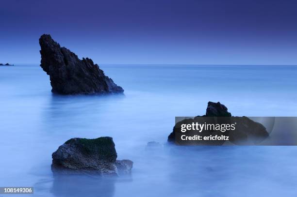 rocks along shoreline at dusk - newport beach california stock pictures, royalty-free photos & images