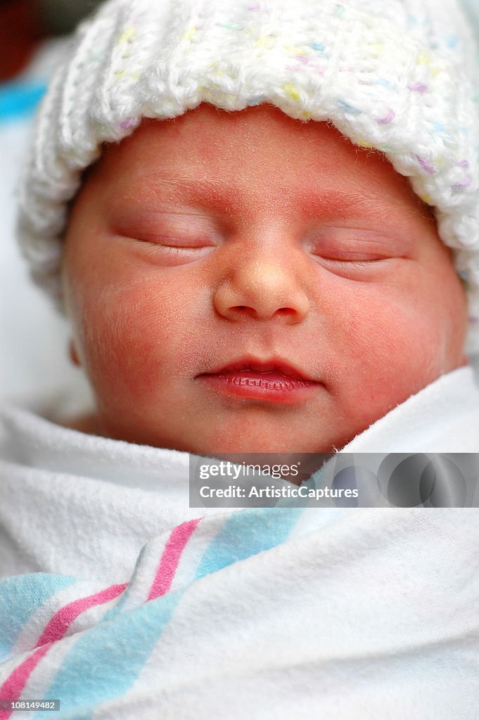 Color Image of Sleeping Newborn Baby Wrapped in Hospital Blanket