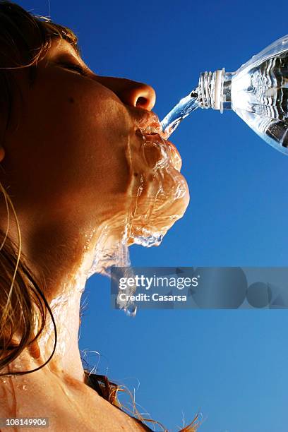 portrait of young woman drinking water - damp lips stock pictures, royalty-free photos & images