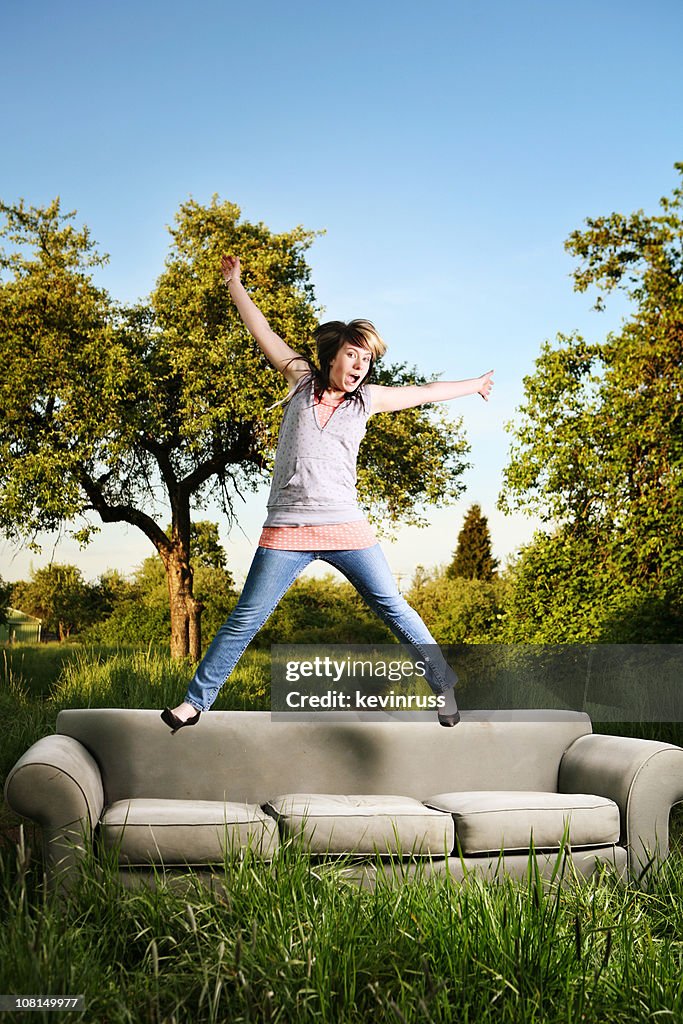 Glückliche junge Mädchen springen auf einem Sofa