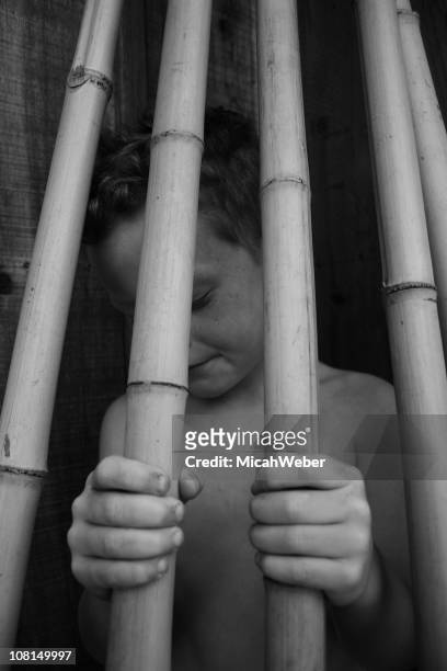 kind hinter bars. - child behind bars stock-fotos und bilder