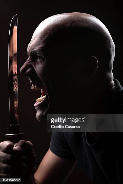 retrato de jovem homem irritado com faca grande, low key - vingança - fotografias e filmes do acervo
