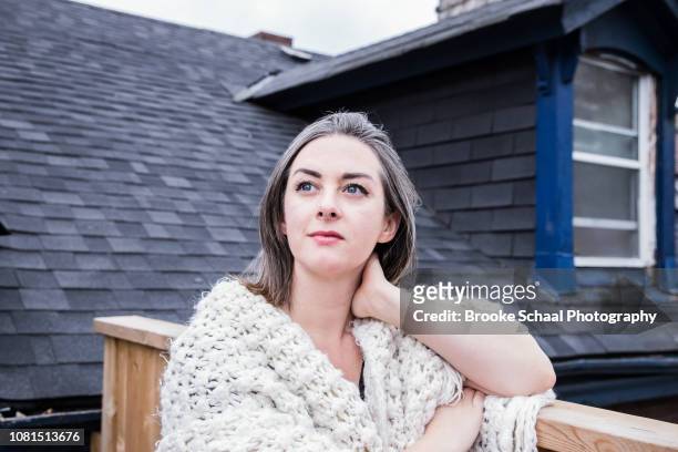 woman on a porch wrapped in a blanket - young woman gray hair stock pictures, royalty-free photos & images