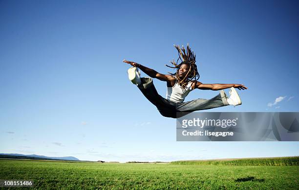 young man jumping in air and doing splits - split acrobatiek stockfoto's en -beelden