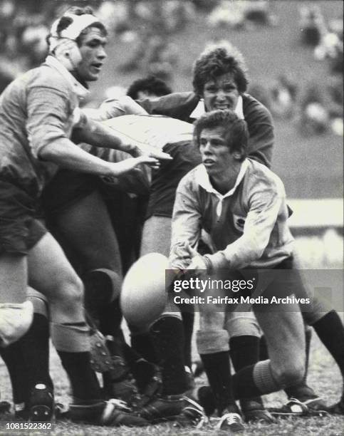 Breakaway Andy Stewart watches halfback Peter Carson whip a Pass away from the Scrum base, with Irish captain Fergus Slattery looming Menacingly, in...