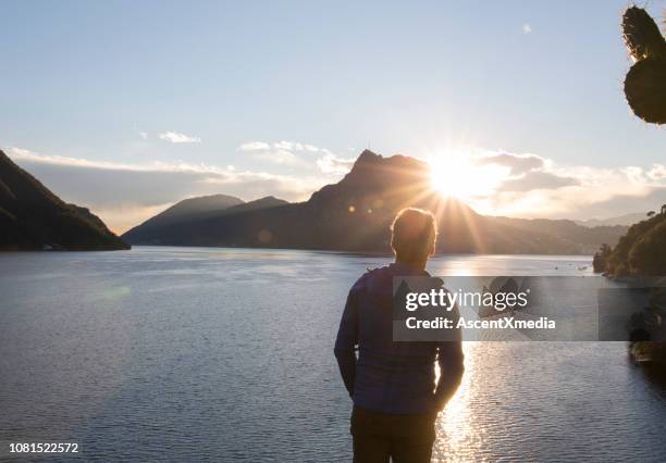 kijk voorbij de man meer, de zon en de bergen - horizontaal stockfoto's en -beelden