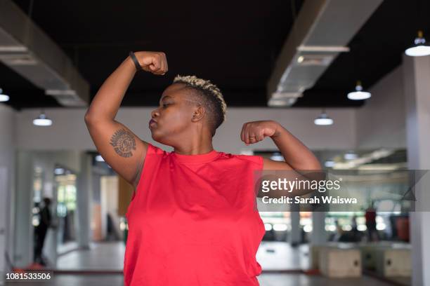 Black woman kissing her muscles at the gym
