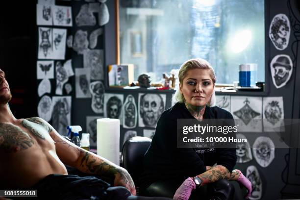 proud female tattoo artist with blonde hair facing camera - tattooing stock-fotos und bilder