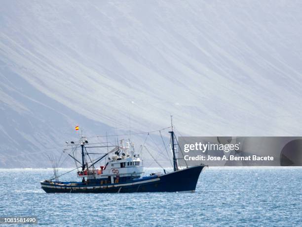ship of industrial fishing being working at the ocean atlantic close to the coasts of an island. lanzarote island, canary islands, spain. - barco pesquero fotografías e imágenes de stock