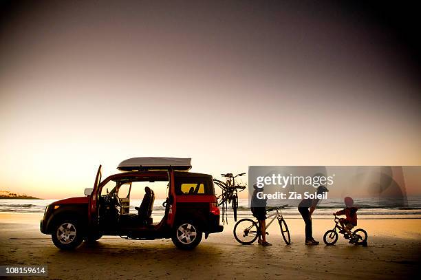 family on beach with bikes and car, sunset - adventure sunset stock pictures, royalty-free photos & images