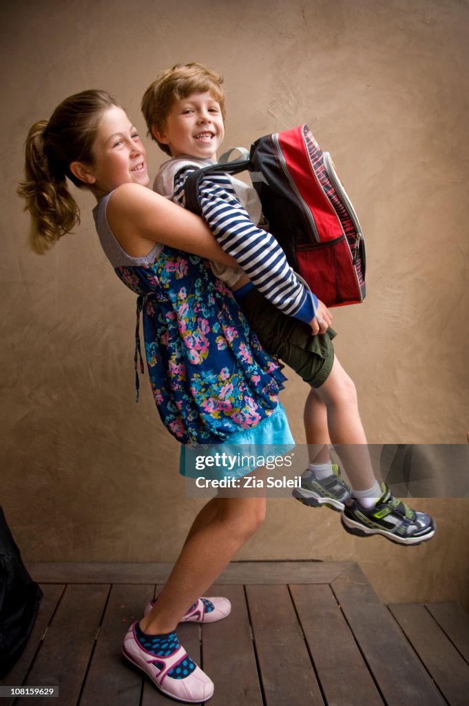 Girl lifting her little brother