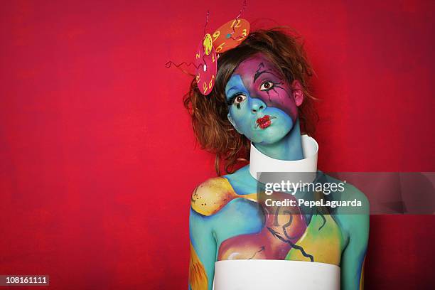 woman with colorful body paint posing on pink background - female body painting 個照片及圖片檔