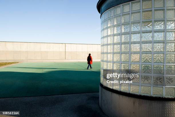 mujer caminar en el último piso - glass cube fotografías e imágenes de stock