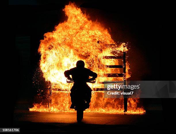 motorbike driving through wall of fire - stuntman stockfoto's en -beelden