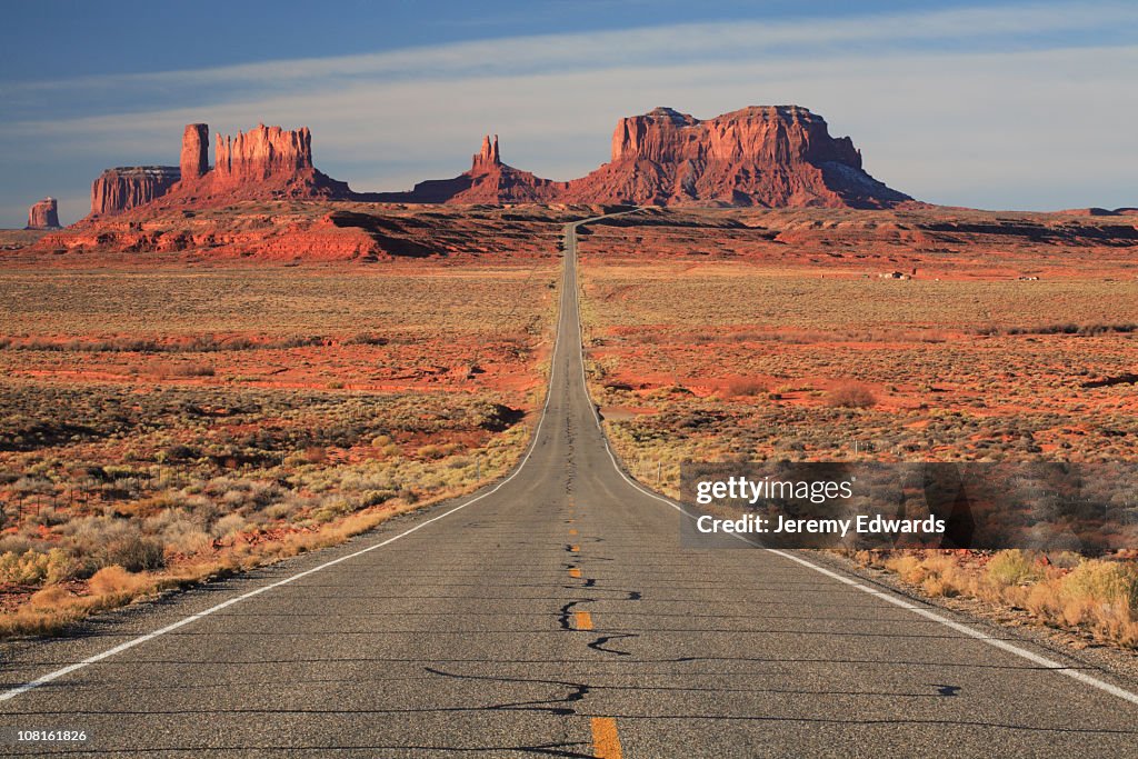 Empty paved road leading to Monument Valley