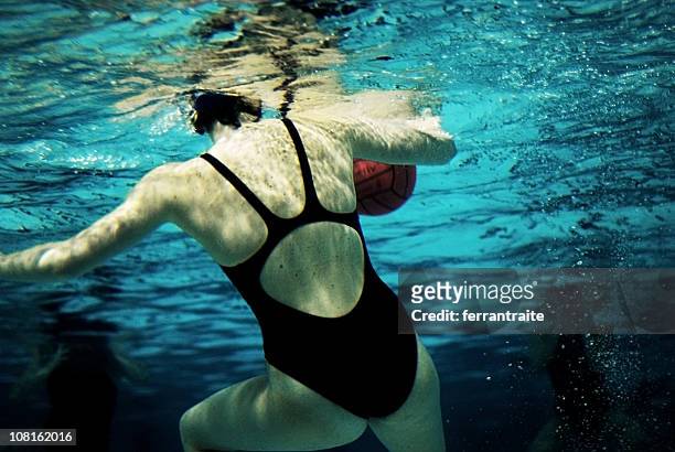 vista submarina de mujer tocando waterpolo - waterpolo fotografías e imágenes de stock