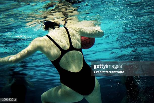 underwater view of woman playing waterpolo - water polo stock pictures, royalty-free photos & images