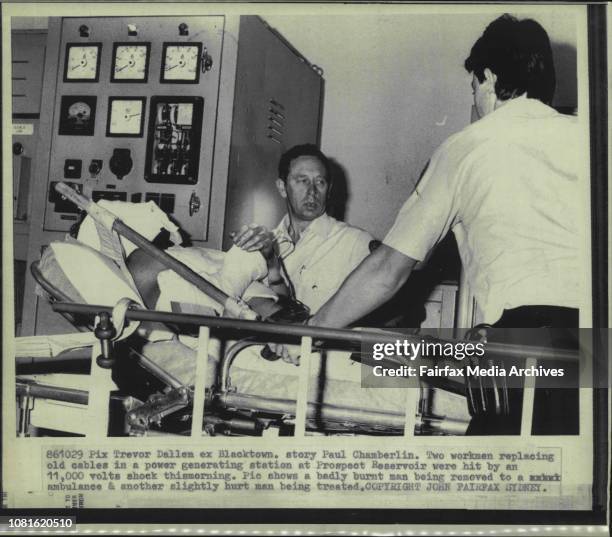 Badly burnt man being removed to a ambulance & another slightly hurt man being treated.Two workers replacing old cables in a power generating...