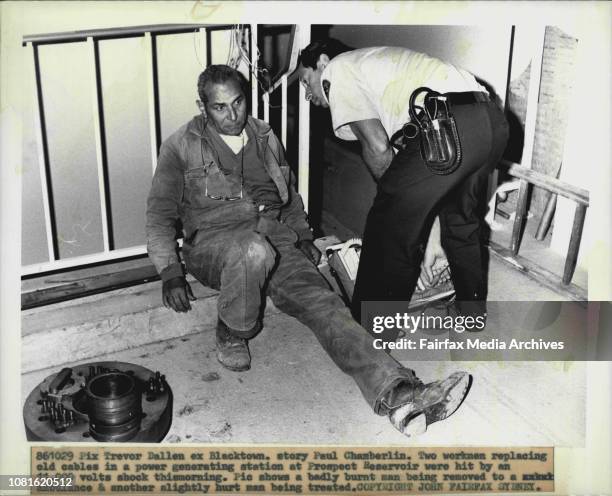 Badly burnt man being removed to a ambulance & another slightly hurt man being treated.Two workers replacing old cables in a power generating...