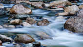 Close-up of clear water flowing through pebbles in stream