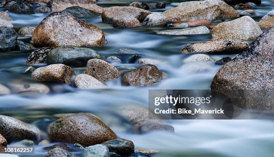 Close-up of clear water flowing through pebbles in stream Close-up of clear water flowing through pebbles in stream
