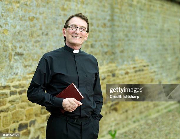 sacerdote retención biblia - minister fotografías e imágenes de stock