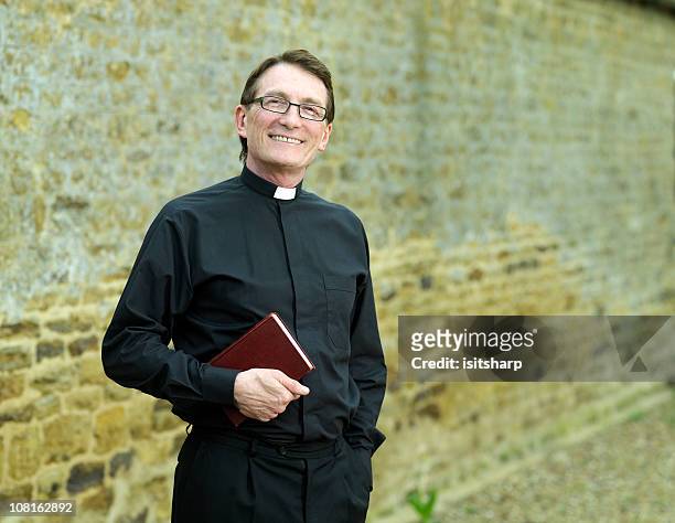 sacerdote tenendo bibbia - minister foto e immagini stock