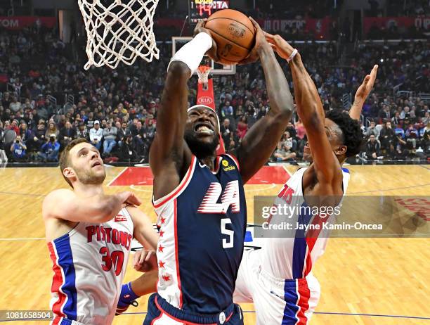 Luke Kennard and Stanley Johnson of the Detroit Pistons defend as Montrezl Harrell of the Los Angeles Clippers goes for a dunk in the first half of...
