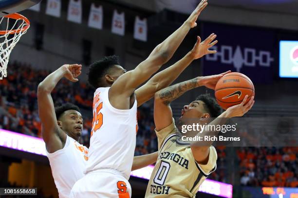 Michael Devoe of the Georgia Tech Yellow Jackets shoots the ball against the defense of Tyus Battle and Elijah Hughes of the Syracuse Orange at the...