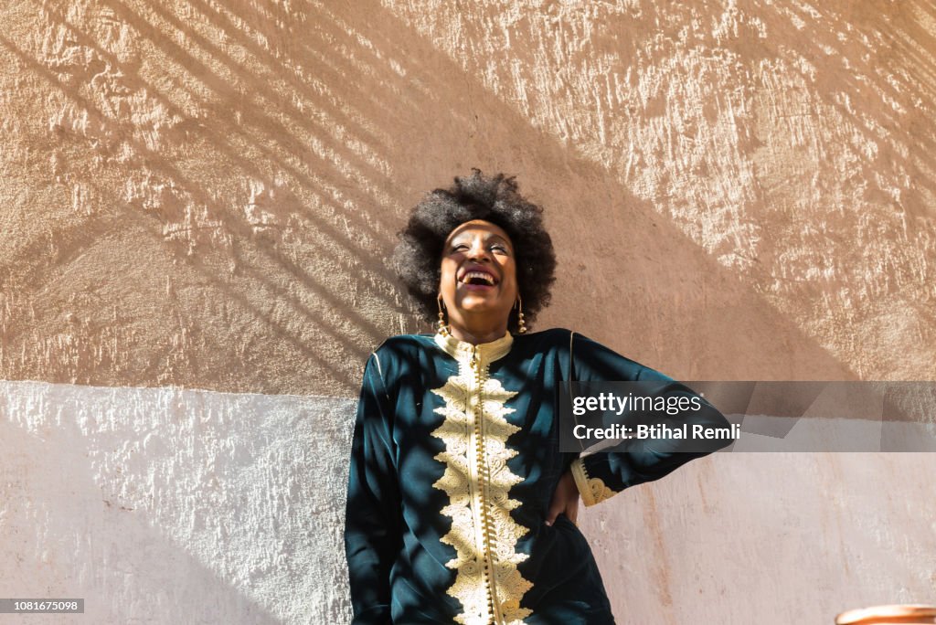 Woman standing on a wall with light and shade