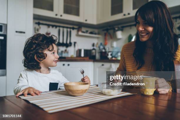 kleine jungen und mama auf dem tisch - baby spielt mit essen stock-fotos und bilder