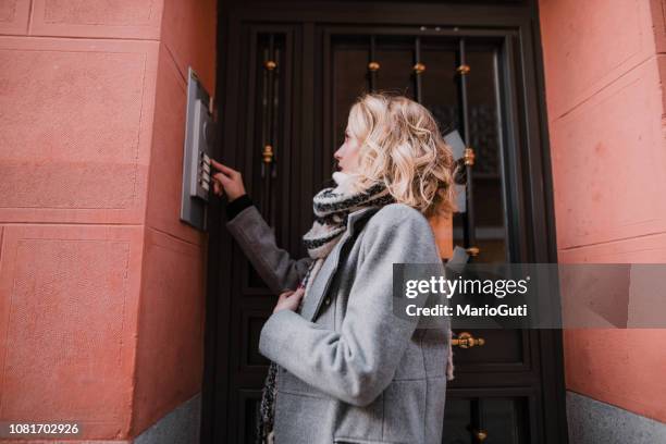 vrouw een appartement bel rinkelen - aanbellen stockfoto's en -beelden