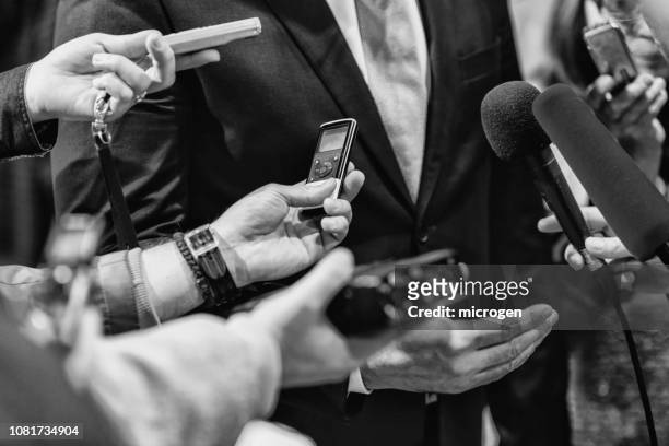 cropped hands of journalists interviewing businessman - journalism stock pictures, royalty-free photos & images