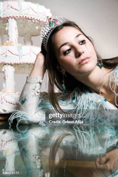 young woman wearing crown crying near birthday cake - sad birthday stock pictures, royalty-free photos & images