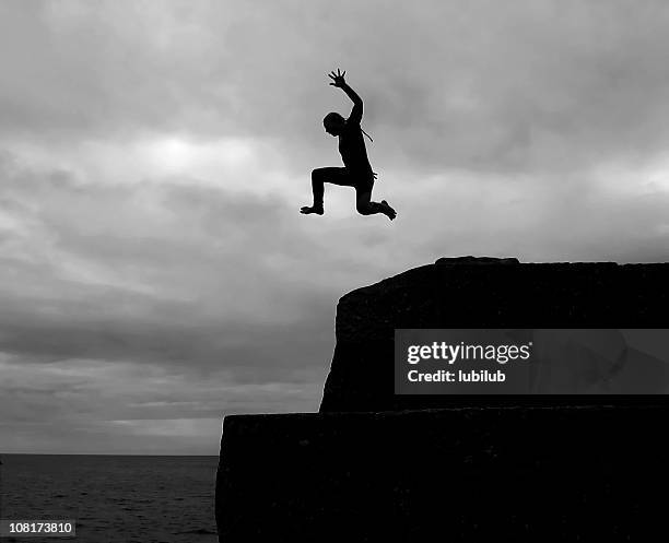 puedo vuelo. silhouette of young boy clavada - salto desde acantilado fotografías e imágenes de stock