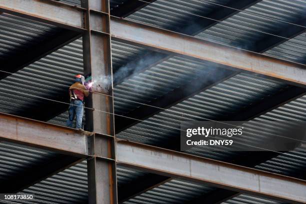 edilizia operaio saldatura a fascio in alto edificio - trave foto e immagini stock