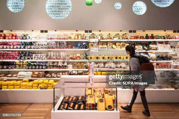 Customer seen shopping from a selection of Netherlands cheese at Amsterdam Schiphol Airport store.