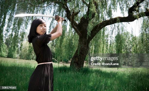 young ninja girl in summer dress with sword - fighting stance stock pictures, royalty-free photos & images
