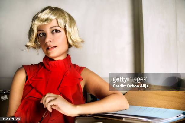young woman sitting near file folder wearing wig - blond wig stock pictures, royalty-free photos & images