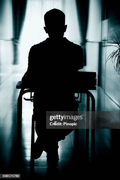 silhouette of student at desk in hallway - straffen stockfoto's en -beelden