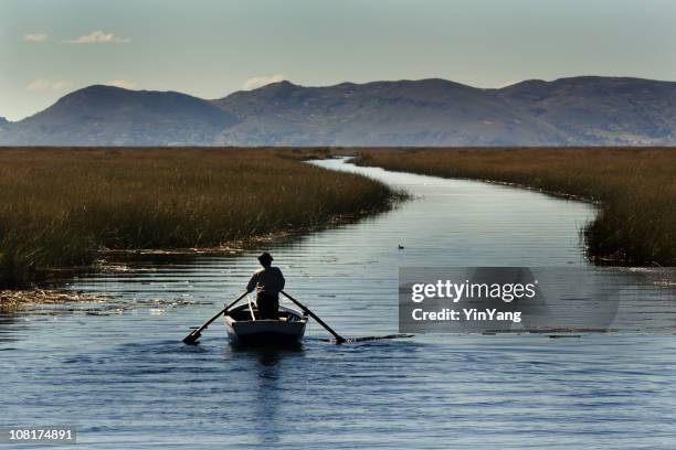 man rowing boat on lake titicaca river, peru, south america - titicacameer stockfoto's en -beelden