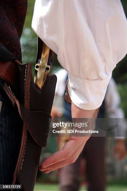 man ready to draw gun in wild west shoot out - holster stock pictures, royalty-free photos & images