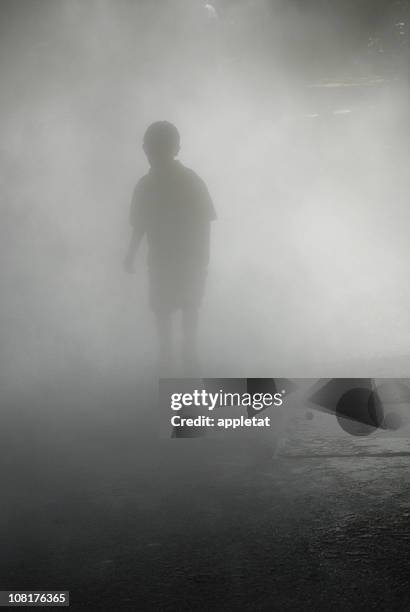 silhouette of boy walking through heavy fog - souls of my young sisters press reception stockfoto's en -beelden