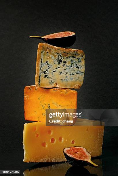 three gourmet cheeses in a stack with decorative figs - cheese stockfoto's en -beelden