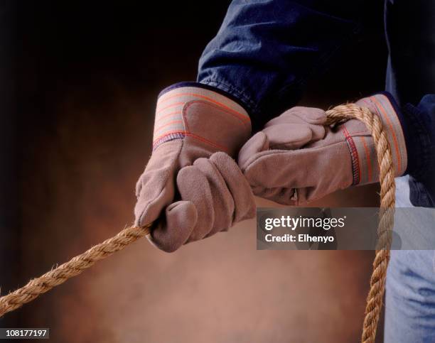 pair of gloved hands pulling on rope - tug of war hands stock pictures, royalty-free photos & images
