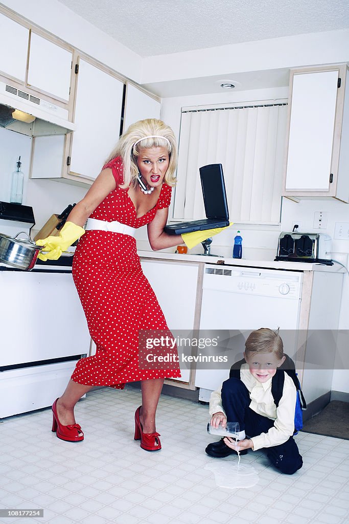 Largo rojo de lunares madre con su hijo en la cocina