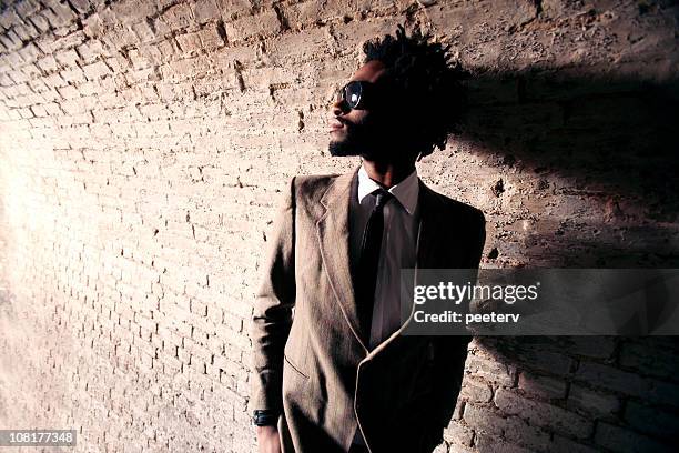 young man wearing suit and standing in tunnel - black suit sunglasses stock pictures, royalty-free photos & images