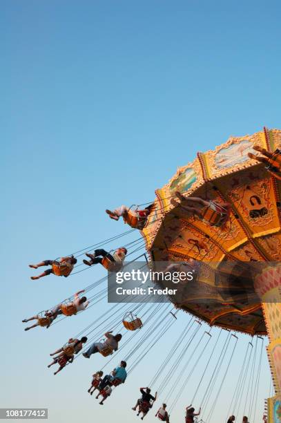 persone equitazione swing giostra - giostra foto e immagini stock