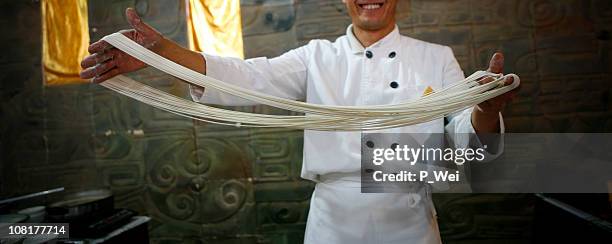 chinesischer chefkoch mit handgemachte nudeln - cooking show stock-fotos und bilder