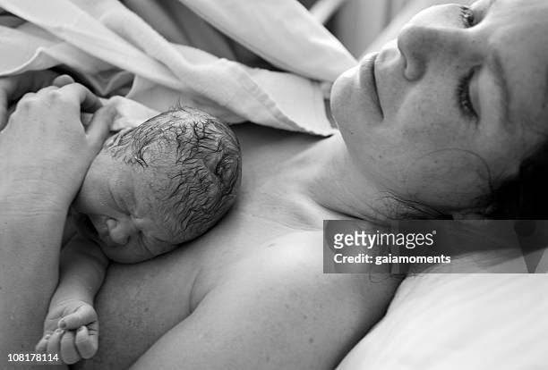 neugeborenes baby auf dem bauch liegen mutter, schwarz und weiß - neu stock-fotos und bilder